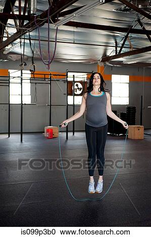 Pregnant young woman skipping with rope View Large Photo Image Stock Image - Pregnant young woman skipping with rope. Fotosearch