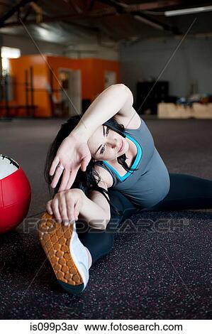 Stock Photo - Pregnant young woman stretching to touch toes. Fotosearch