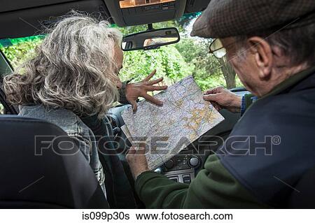 Senior couple in car, looking at map View Large Photo Image Stock Photograph - Senior couple in car, looking at map. Fotosearch