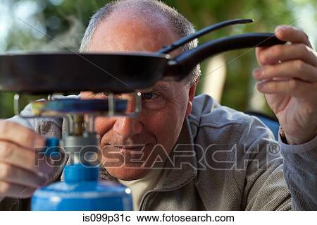 Senior man cooking on camping stove View Large Photo Image Stock Image - Senior man cooking on camping stove. Fotosearch