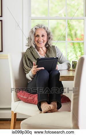 Senior woman using digital tablet at home View Large Photo Image Stock Photography - Senior woman using digital tablet at home. Fotosearch