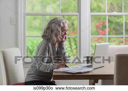 Senior woman using laptop at home View Large Photo Image Picture - Senior woman using laptop at home. Fotosearch