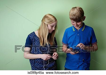 Teenage boy and teenage girl with mp3 players View Large Photo Image Stock Image - Teenage boy and teenage girl with mp3 players. Fotosearch