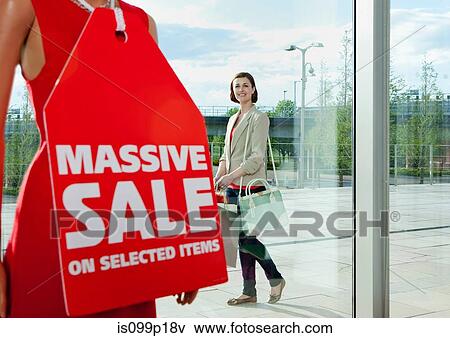 Woman looking at sale sign in shop window View Large Photo Image Stock Photo - Woman looking at sale sign in shop window. Fotosearch