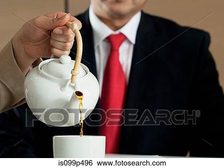 Woman pouring tea for businessman View Large Photo Image Stock Photograph - Woman pouring tea for businessman. Fotosearch