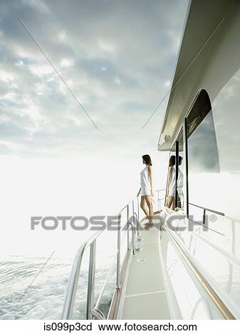 Stock Image - Woman standing on yacht. Fotosearch