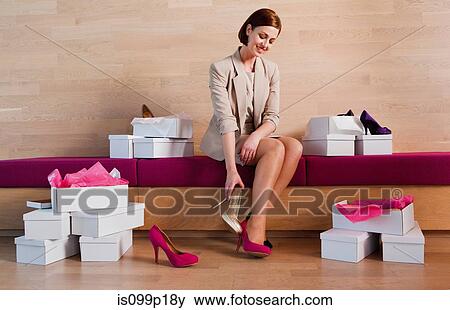Stock Photo - Woman trying on shoes in shoe shop. Fotosearch