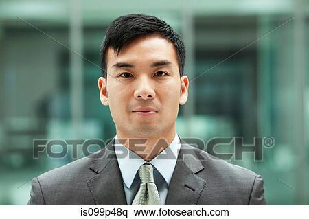 Stock Photography - Young businessman looking at camera, portrait. Fotosearch