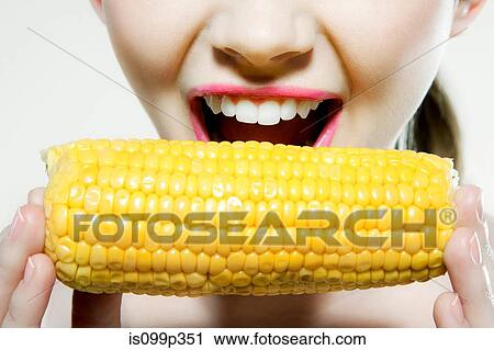 Young woman biting corn cob View Large Photo Image Stock Image - Young woman biting corn cob. Fotosearch