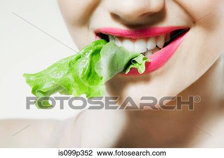 Young woman biting lettuce View Large Photo Image Stock Image - Young woman biting lettuce. Fotosearch