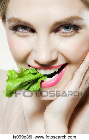 Young woman biting lettuce View Large Photo Image Stock Image - Young woman biting lettuce. Fotosearch