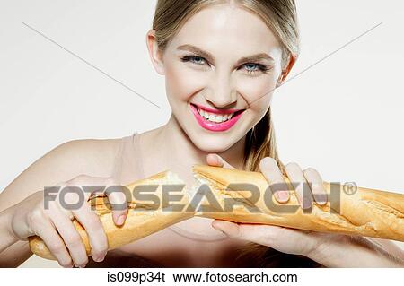 Stock Photograph - Young woman breaking baguette. Fotosearch