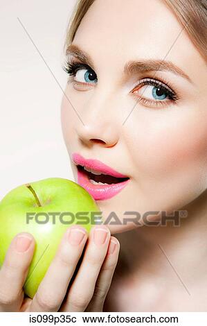 Stock Image - Young woman eating apple. Fotosearch