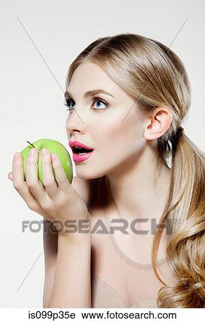 Stock Image - Young woman eating apple. Fotosearch