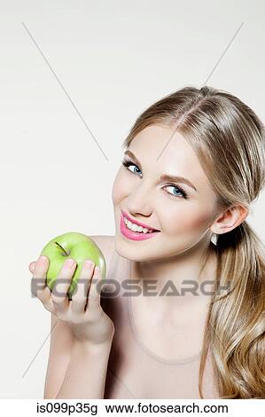 Stock Image - Young woman eating apple. Fotosearch