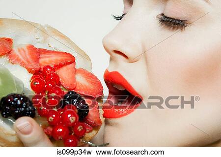 Young woman eating fresh fruit View Large Photo Image Stock Photo - Young woman eating fresh fruit. Fotosearch