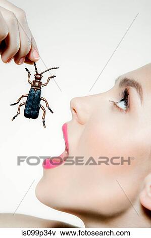 Young woman eating plastic beetle View Large Photo Image Stock Photo - Young woman eating plastic beetle. Fotosearch