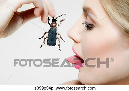 Young woman eating plastic beetle View Large Photo Image Stock Photography - Young woman eating plastic beetle. Fotosearch