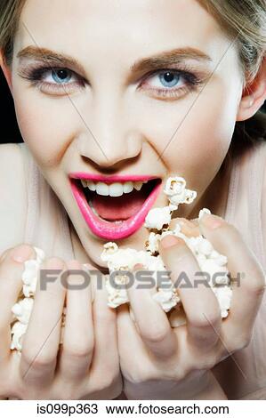 Young woman eating popcorn View Large Photo Image Stock Image - Young woman eating popcorn. Fotosearch