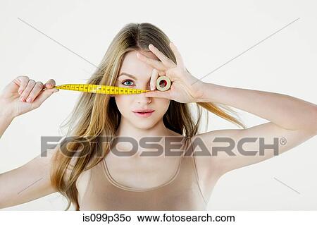 Young woman holding tape measure View Large Photo Image Picture - Young woman holding tape measure. Fotosearch