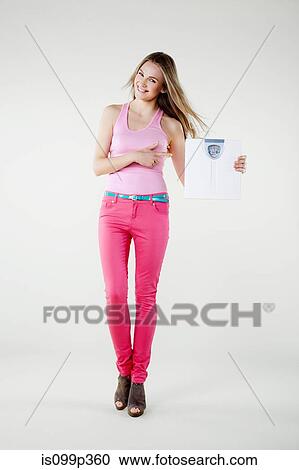 Stock Image - Young woman holding weight scales. Fotosearch