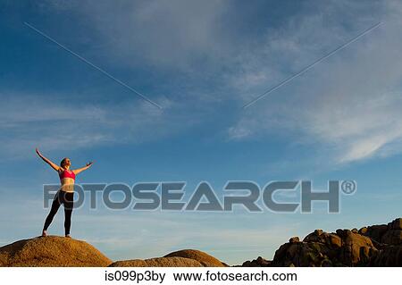 Young woman standing in desert with arms open View Large Photo Image Stock Photo - Young woman standing in desert with arms open. Fotosearch