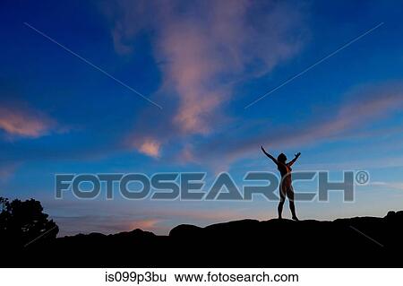 Young woman standing in desert with arms open, silhouette View Large Photo Image Stock Photograph - Young woman standing in desert with arms open, silhouette. Fotosearch