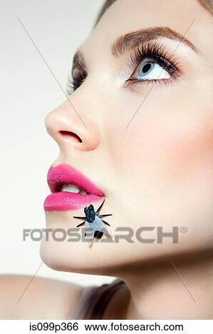 Stock Photograph - Young woman with plastic fly on face. Fotosearch