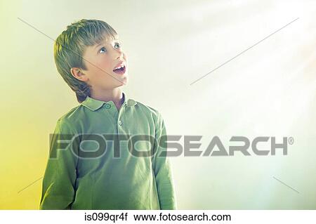 Stock Image - Boy looking up at light. Fotosearch