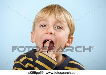 Stock Photography - Boy pointing to gap in teeth. Fotosearch