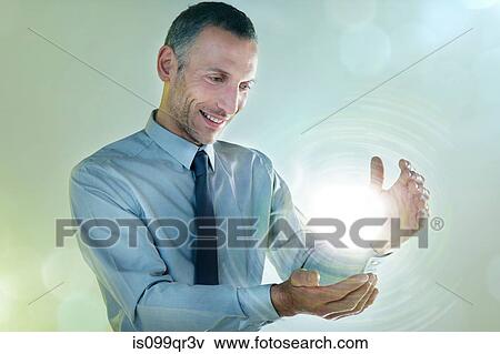 Stock Photo - Businessman holding ball of light. Fotosearch