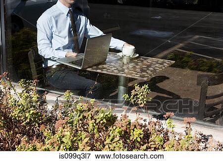 Stock Photo - Businessman in cafe, view through window. Fotosearch