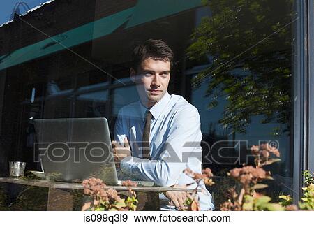 Stock Photo - Businessman in cafe, view through window. Fotosearch