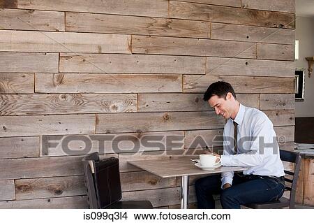 Picture - Businessman sitting at table in cafe. Fotosearch