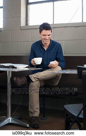 Businessman texting in cafe View Large Photo Image Stock Photograph - Businessman texting in cafe. Fotosearch