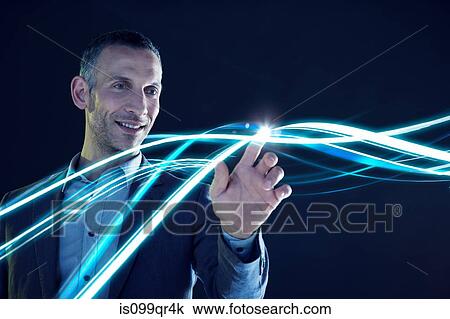 Stock Image - Businessman touching lines of light. Fotosearch