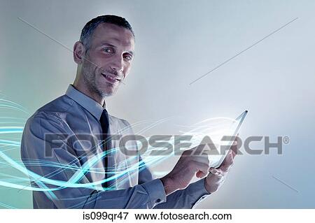 Stock Photo - Businessman using digital tablet with lights. Fotosearch