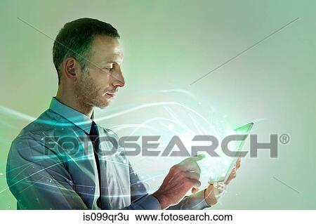 Stock Photograph - Businessman using digital tablet with lights. Fotosearch