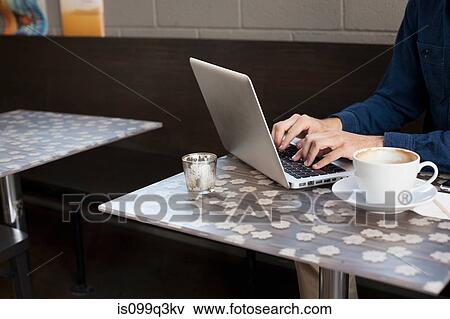 Stock Photo - Businessman using laptop in cafe. Fotosearch