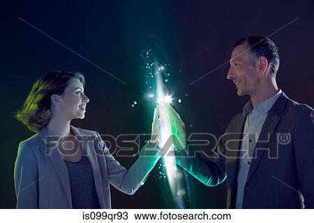 Stock Image - Businesspeople connecting through light. Fotosearch