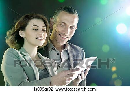 Stock Image - Businesspeople looking at digital tablet. Fotosearch