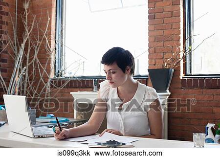 Businesswoman in office making notes View Large Photo Image Stock Image - Businesswoman in office making notes. Fotosearch