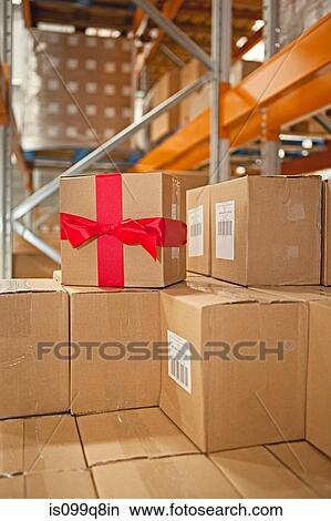 Cardboard box with red bow in warehouse View Large Photo Image Picture - Cardboard box with red bow in warehouse. Fotosearch
