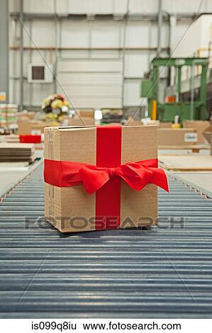 Cardboard box with red bow on conveyor belt View Large Photo Image Stock Photograph - Cardboard box with red bow on conveyor belt. Fotosearch