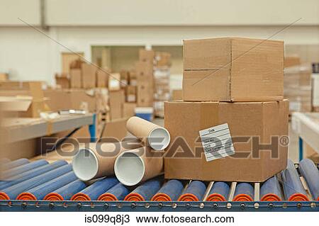 Stock Image - Cardboard boxes and tubes on conveyor belt. Fotosearch
