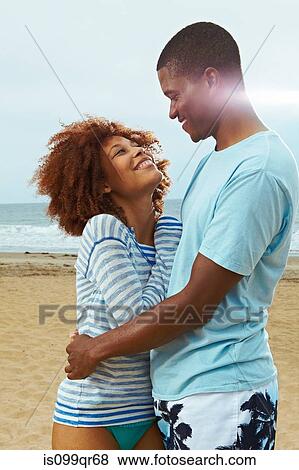 Couple embracing on beach View Large Photo Image Stock Photo - Couple embracing on beach. Fotosearch
