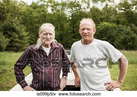 Father and son looking at camera, portrait View Large Photo Image Stock Photo - Father and son looking at camera, portrait. Fotosearch