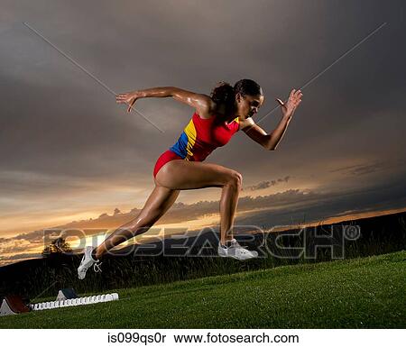 Stock Photography - Female athlete leaving starting blocks. Fotosearch