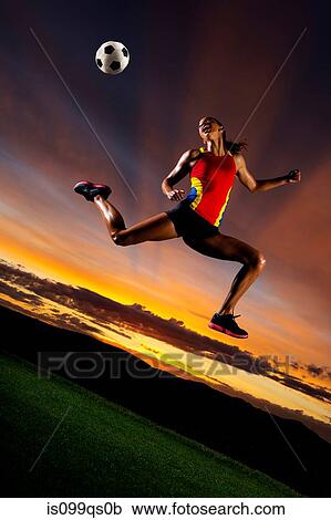 Female footballer in mid air against sunset View Large Photo Image Stock Image - Female footballer in mid air against sunset. Fotosearch