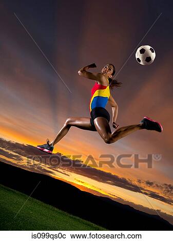 Female footballer in mid air against sunset View Large Photo Image Stock Image - Female footballer in mid air against sunset. Fotosearch